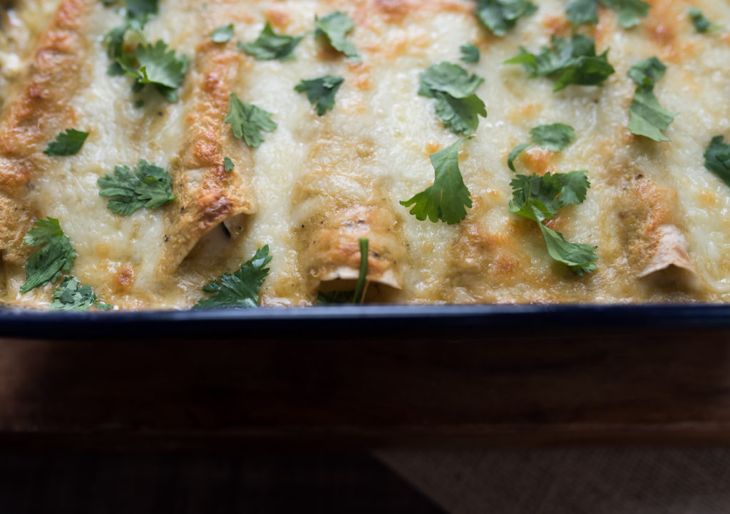 Hatch Green Chile Enchiladas smothered in a delicious sour cream sauce. Stuffed with Shredded chicken and spinach; Also Freezer Friendly! 