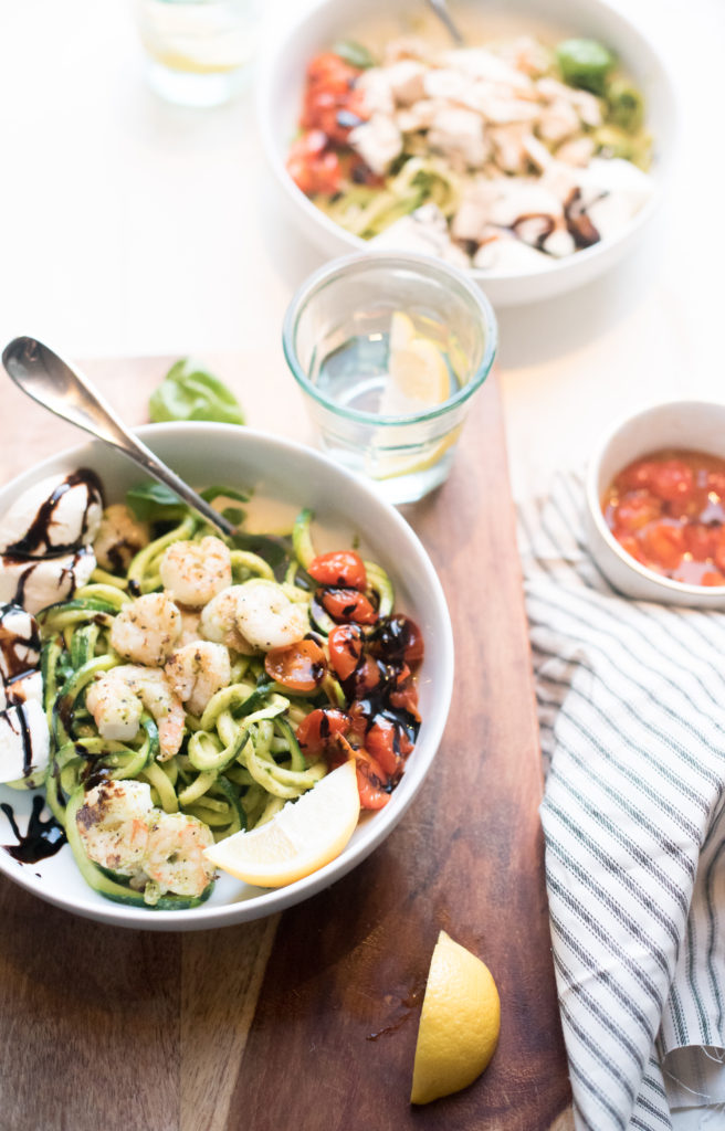 Shrimp and Zucchini noodles tossed in a delectable pesto with fresh burrata cheese and oven roasted tomatoes. Everything gets drizzled with a sweet balsamic glaze. Best part: It can be made in 20 minutes. | FirstandFull.com