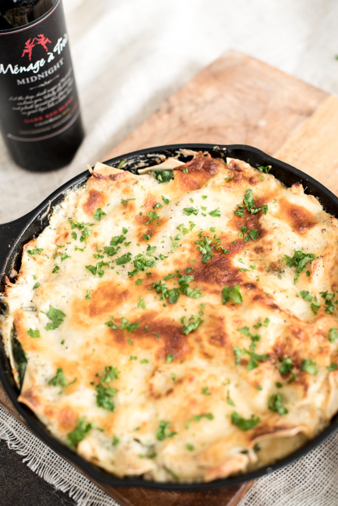 Chicken Alfredo Skillet Lasagna with a homemade garlic cream sauce, shredded chicken, fresh herbs, shredded cheese, all layered in a skillet and baked!