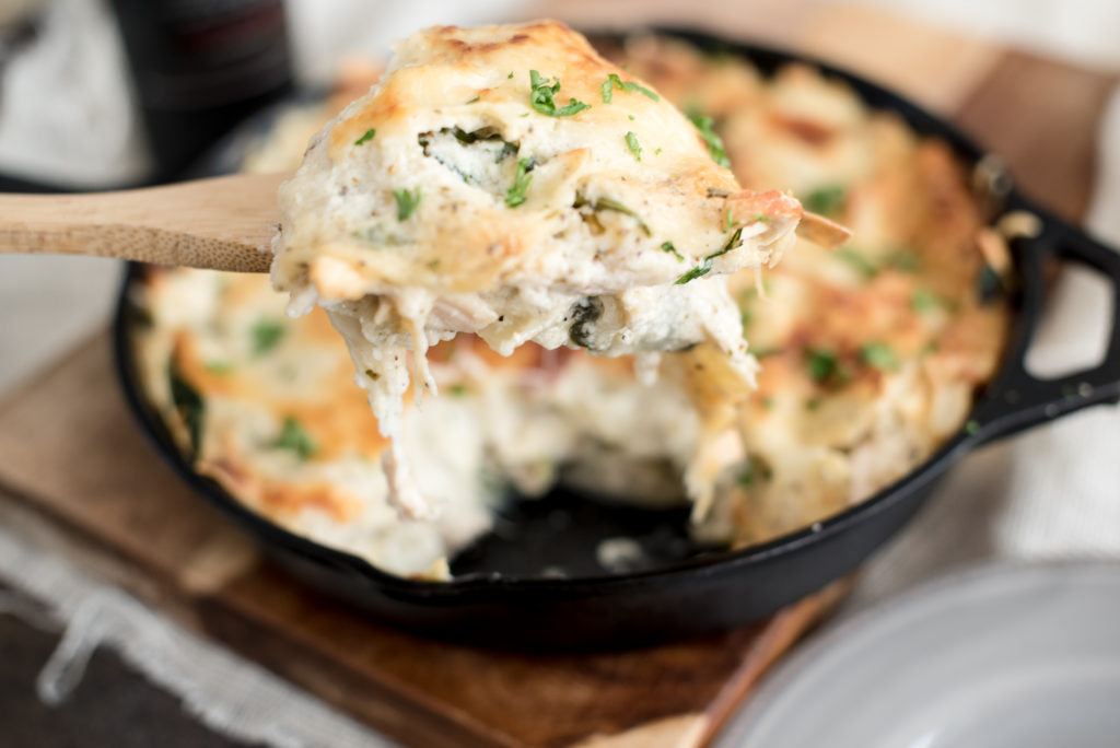 Chicken Alfredo Skillet Lasagna with a homemade garlic cream sauce, shredded chicken, fresh herbs, shredded cheese, all layered in a skillet and baked!