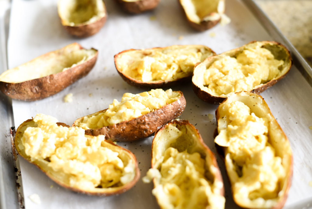 A fun, hand held breakfast option: Crispy Breakfast baked potato skins topped with scrambled eggs, garlicky spinach, chopped, crispy bacon, and a dollop of fresh pesto. Plus, tons of ways to customize and change things up! 