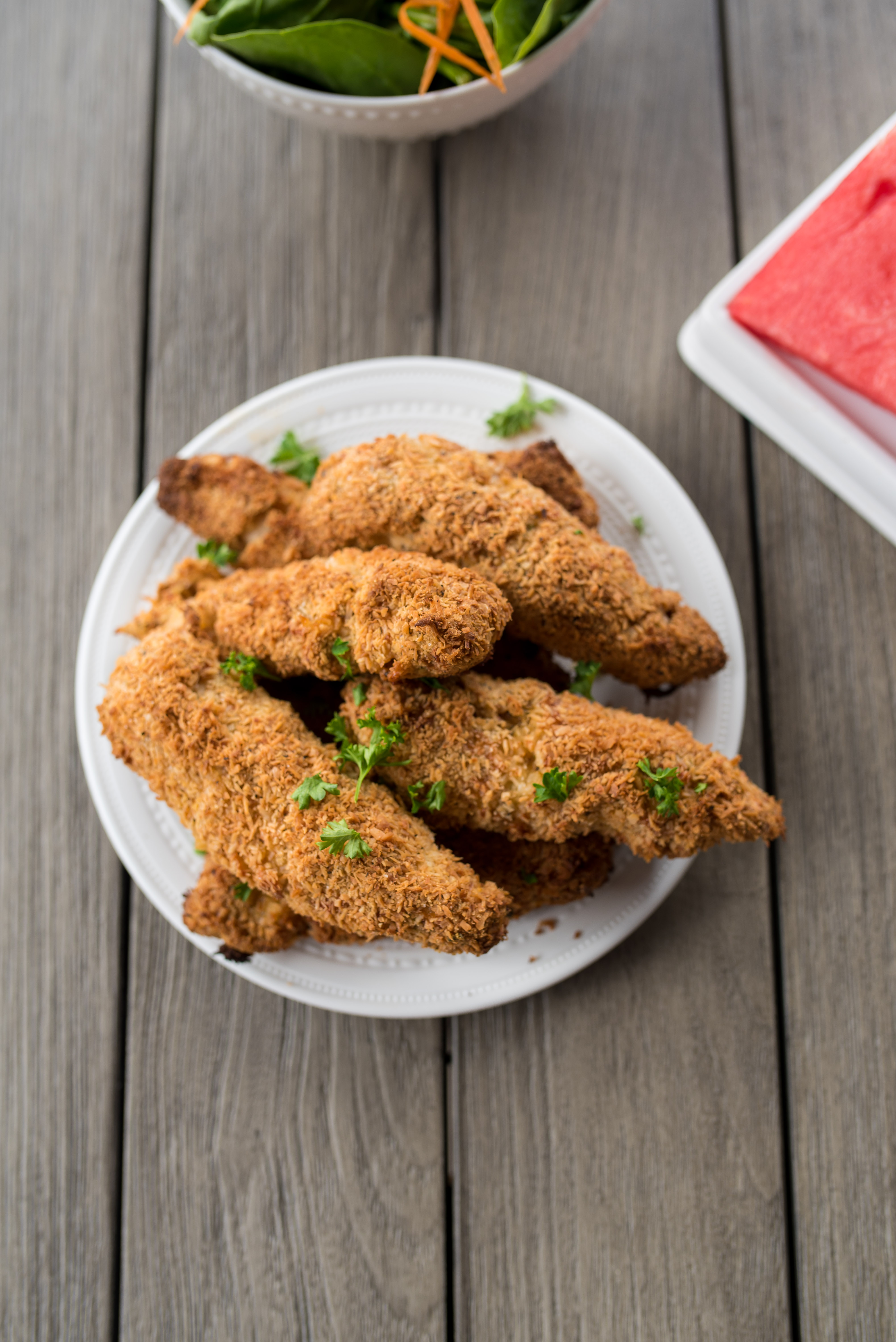 Crispy, Whole30 Chicken tenders breaded with seasoned almond flour, unsweetened coconut and BAKED to perfect! Delicious when dunked in dairy- free, roasted garlic ranch and are freezer friendly! The whole family will love these Whole30 Chicken Tenders.