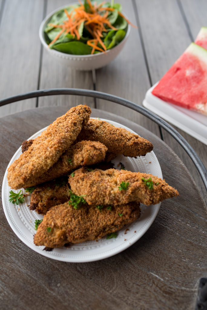 Crispy, Whole30 Chicken tenders breaded with seasoned almond flour, unsweetened coconut and BAKED to perfect! Delicious when dunked in dairy- free, roasted garlic ranch and are freezer friendly! The whole family will love these Whole30 Chicken Tenders.