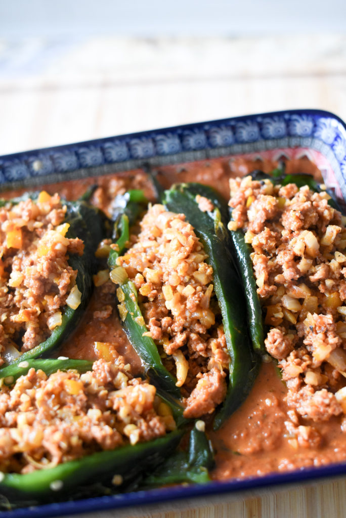 Enchilada Stuffed Poblano Peppers: Fire roasted poblano peppers, deseeded and stuffed with a delicious chorizo filling packed with onions, garlic, bell peppers, and cauliflower rice. They are then nestled into a smoky enchilada sauce and baked till bubbly.