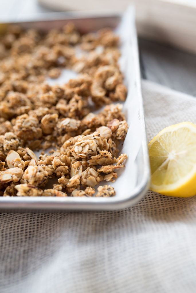 Close up of Lemon Chia Seed Granola on a tray with a halved lemon.