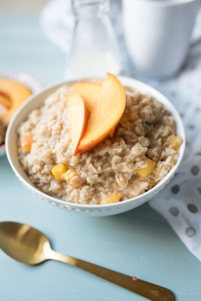 Sweet and Creamy oatmeal with ripe peaches sautéed in brown sugar and a healthy drizzle of cream at the end. A decadent breakfast in a bowl. 