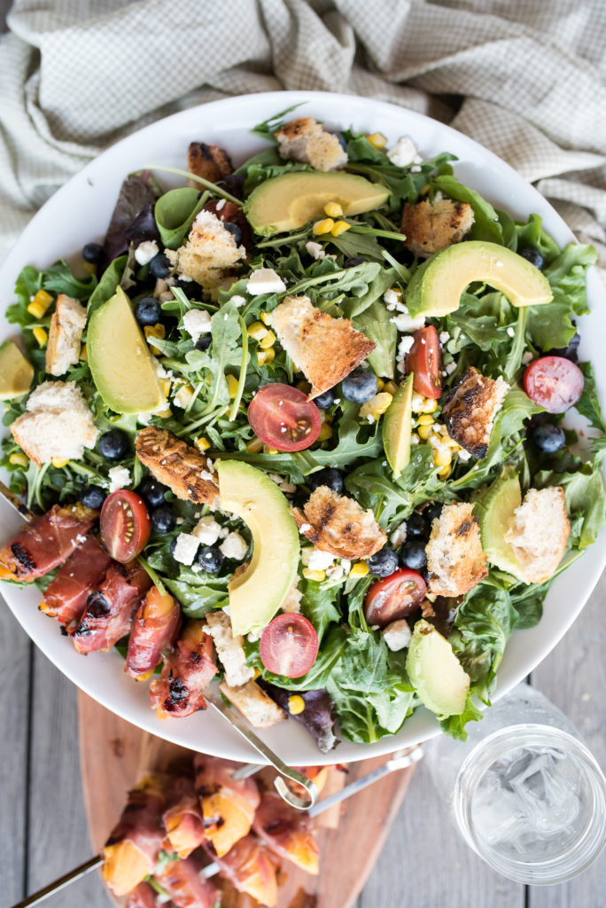 This Grilled Prosciutto wrapped peach panzanella salad is a light and delicious summer salad with grilled prosciutto-wrapped peaches, sweet blueberries, crumbled feta, grilled sourdough and charred corn.